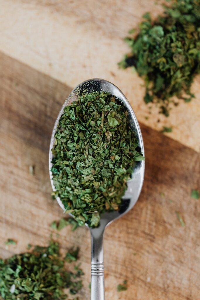 close up photo of green oregano on a spoon